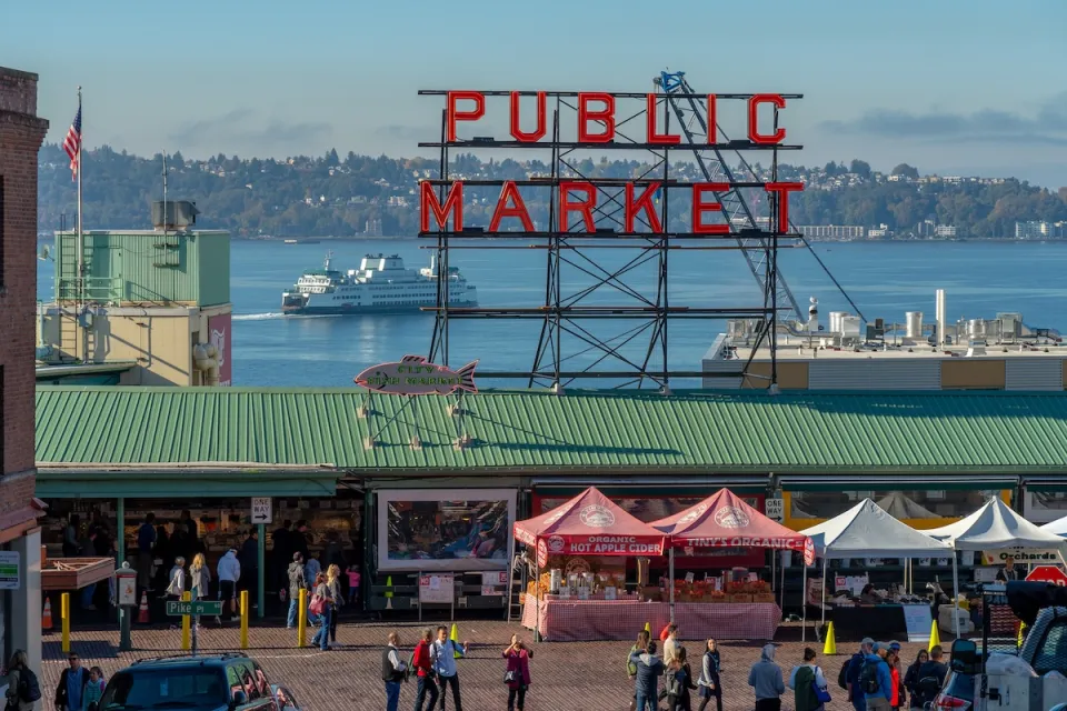 Public Market sign over Pike Place Market in Seattle, Washington with pop-up booths on street.